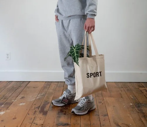 man standing with Sport tote bag with a plant inside